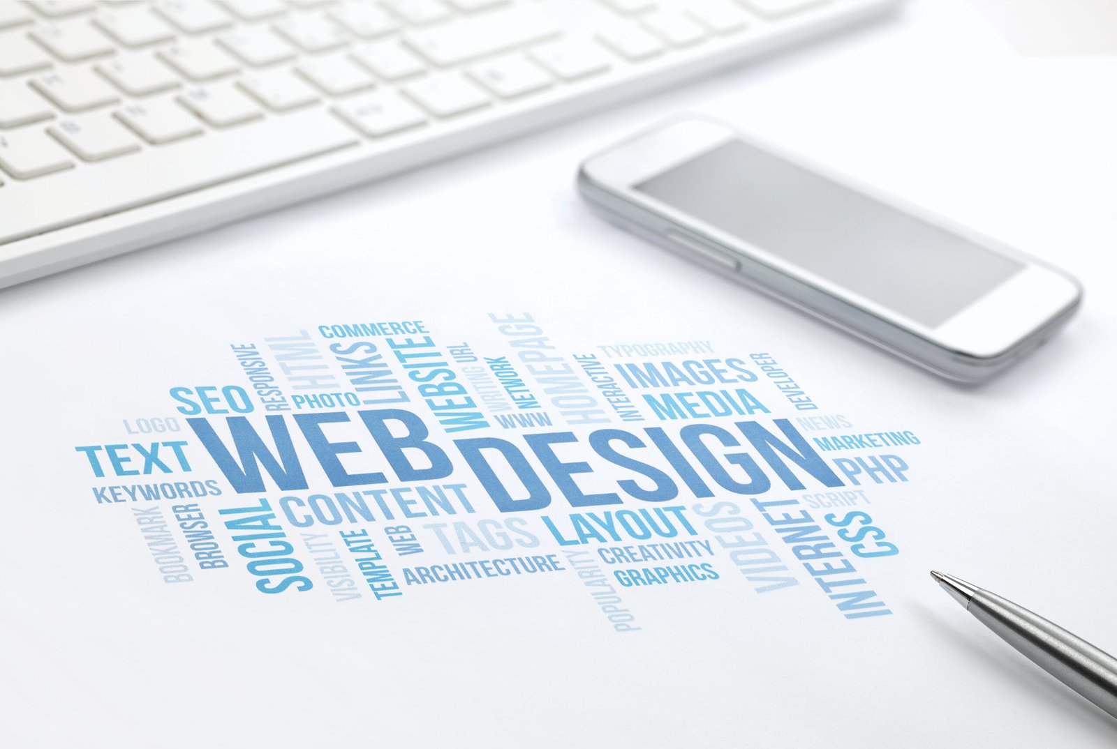 Web Design business concept word cloud print document, keyboard, pen and smartphone, keyboard, pen and smartphone. Blue toned.